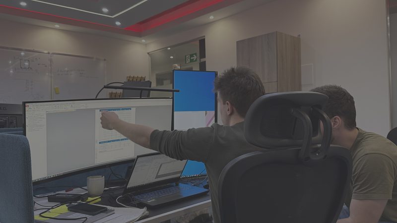 Két mérnök az irodában egy monitoron futó tervdokumentációt egyeztet